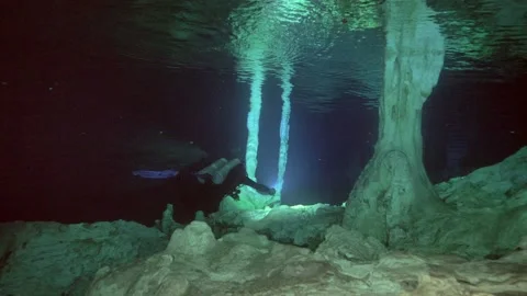 Diver illuminating limestone column with torch Stock-Footage 331790322