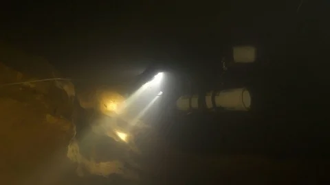 Diver lights up guide line and enters in the dark cave,Risorgenza Amaseno, Italy Stock Footage 109178955