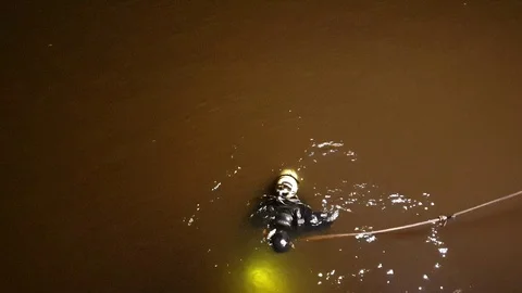 A diver is looking for a drowned man. The search for the drowned. Diver at night Stock Footage 114886020