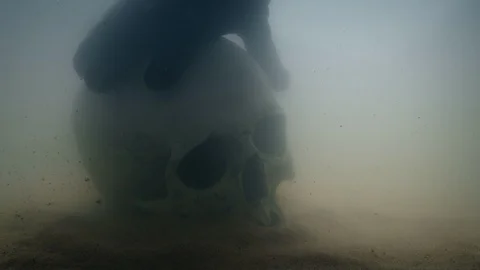 Diver Picks Up Skull From Sea Floor Stock Footage