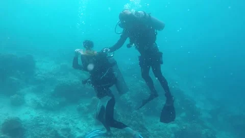 Diver playing game in the deep sea with video shooting by friend Stock-Footage 136596996