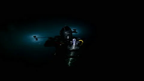 A diver prepares for a night dive, checks the operation of lights and a camera Stock Footage 144099406