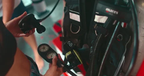Diver preparing scuba diving equipment checking oxygen gauge Stock Footage 311105626