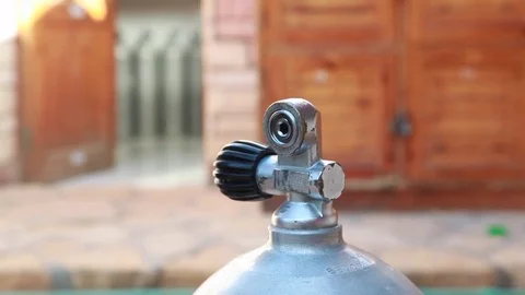 A diver putting a regulator on a dive tank and opens it. Equipment Stock Footage 82731622