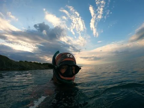 Diver on the sea surface with a background of beautiful clouds Stock Photos