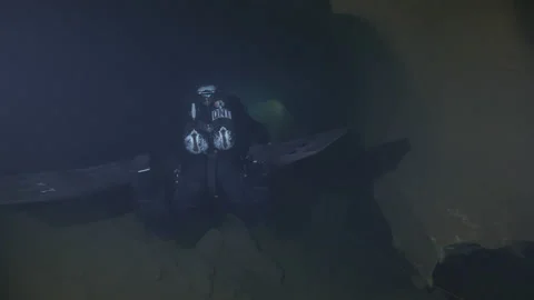 Diver swims between the cracks of the rocks at the bottom of the cave,Amaseno,IT Stock Footage 224689634