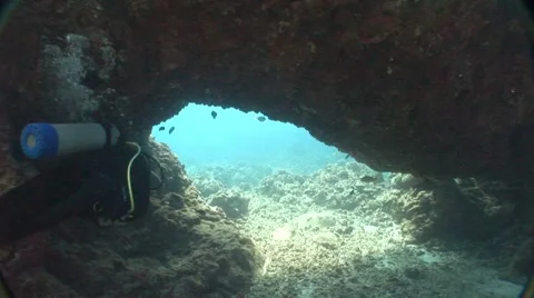 Diver swims out of a cave Stock Footage 5265020