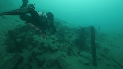 Diver swims on the remains for the dam construction, San Domenico lake, Italy Stock Footage 108687777