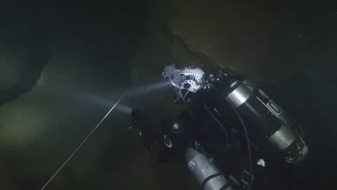 Diver with torch explores the rocks of the underwater cave, Amaseno,Italy Stock Footage 224853621