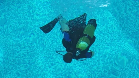 The diver trains to dive in the pool, swimming under water Stock Footage 104258582