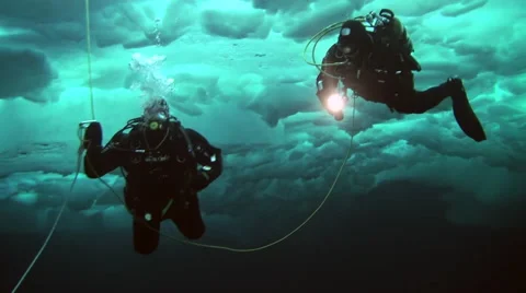 Diver under Arctic ice at the North Pole light the way a flashlight. Stock-Footage 63037030