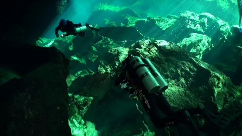 Diver under stalactite stone icicles in cave in underwater Mexico cenotes. 库存影片 119115017