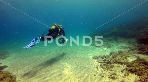 Diver with underwater scooter in turquoise waters Stock Photos