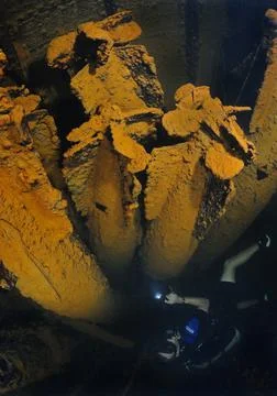 Diver views cargo of long lance torpedoes in sunken Japanese shipwreck Heian Foto stock