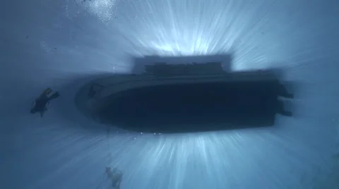 Divers and Boat Silhouetted in Sunrays Stock Footage 53345133