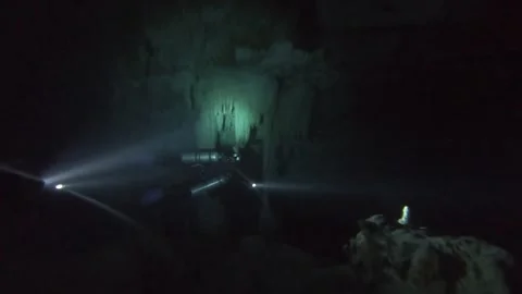Divers in Cave With Flashlights Stockbeeldmateriaal 157185677