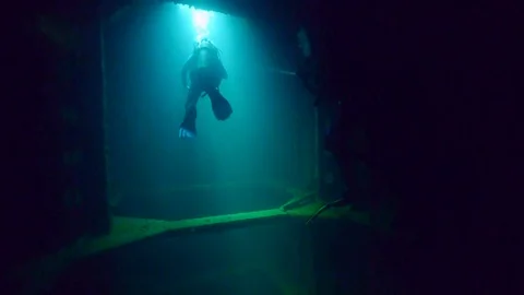 Divers exploring inside the hull of sunken Japanese ship from World War 2 Stock Footage 121834363