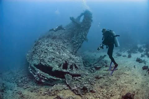 Divers exploring the outside of a wreck Stock Photos