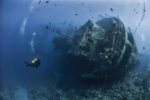 Divers exploring a shipwreck Stock Photos