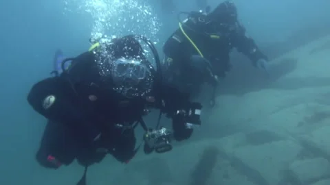 Divers Exploring Underwater World in Clear Blue Waters Stockbeeldmateriaal 321062116