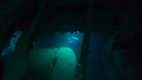 Divers exploring wreck of Japanese ship sunk in WW2 Stock Footage 121832181