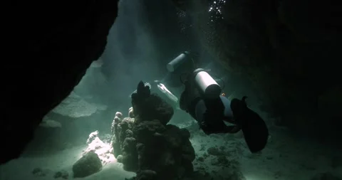 Divers filming in a cavern deep in the redsea Stock Footage 269882140