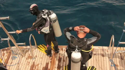 Divers jumping in water Stockbeeldmateriaal 125332581