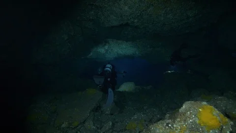 Divers pass through crack under the rocks at the seabed,Ustica,Mediterranean sea Vídeos de archivo 126896488