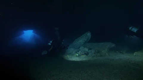 Divers pass through crack under the rocks at the seabed,Ustica,Mediterranean sea Stock Footage 126921019