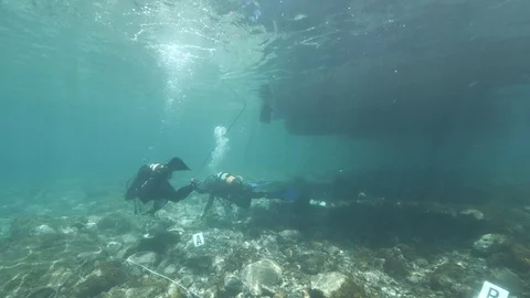 Divers set up a simulation of an underwater crime near their boat,Ustica Med sea Stock Footage 123976776