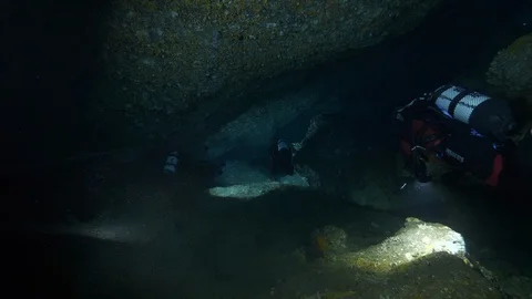 Divers swim in the crevices between the rocks, Ustica, Mediterranean sea Stock Footage 126898607
