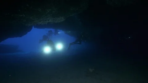 Divers with torches enter in a cave, Ustica, Sicily, Mediterranean sea Stock Footage 126721786