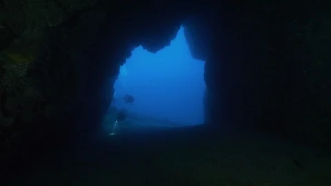 Divers with torches enter in underwater cave; Ustica, Mediterranean sea Stock Footage 126985289