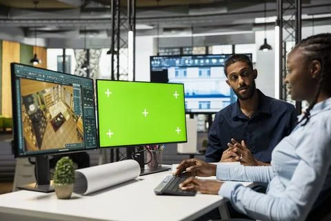 Diverse 3D developers designing building floor plan next to green screen Stock Photos