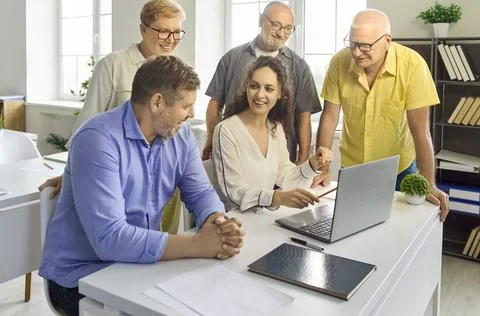 Diverse adult students with instructor learning laptop skills in office training Stock Photos