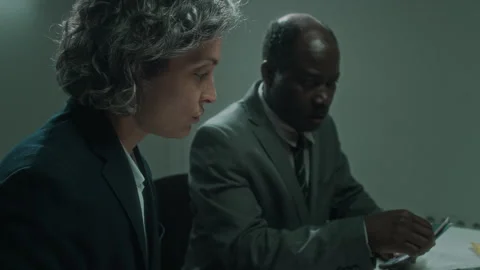 Diverse Agents Interrogating Gang Murder Suspect with Crime Scene Photos Stock Footage 276715543