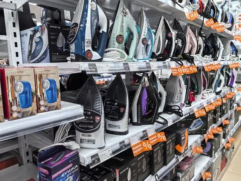 Diverse array of ironing devices displayed in a modern retail store Foto stock