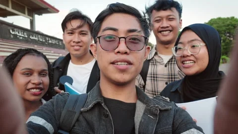 Diverse Asian University students doing a videocall with cell phone at the Stock Footage 306659145