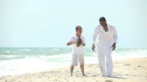 Diverse boy spending time with father playing American football Stock Footage