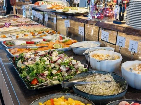 A diverse breakfast buffet spread featuring fresh salads, cured fish, and dairy Stock Photos