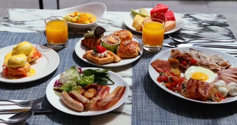 Diverse breakfast spread on marble table with eggs benedict, pastries, Stock Footage 318119863