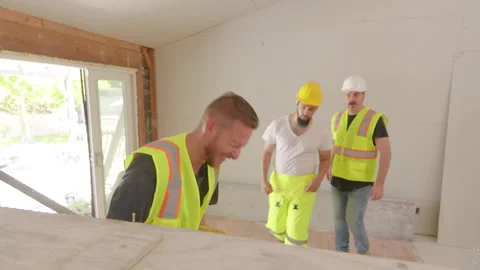 Diverse builders are diligently working on a house renovation at a busy Stock Footage 305434717