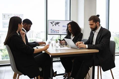 Diverse business team analyzing data in modern office environment Stock Photos