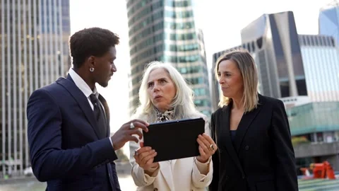 Diverse business team discussing project on tablet in financial district Stock Footage 326415689