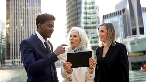 Diverse business team discussing project on tablet in financial district Stock Footage 326415702