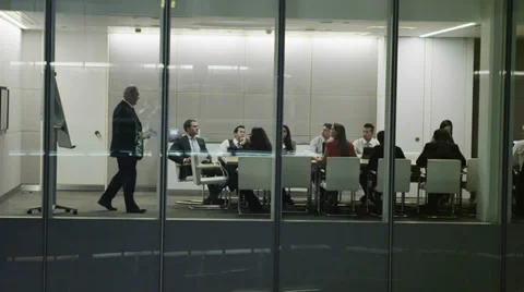 Diverse business team in late night boardroom meeting in contemporary office Stock Footage