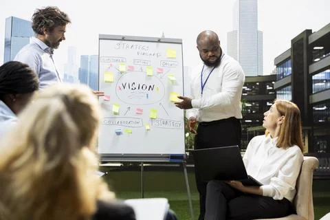 Diverse business team planning roadmap on whiteboard during outdoor meeting Stock Photos