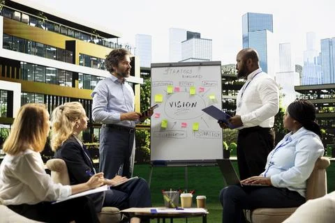 Diverse business team presenting vision roadmap on whiteboard Stock Photos