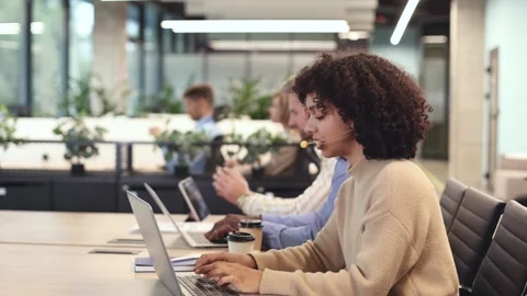 Diverse call center operators providing customer service with headsets Stock Footage 289744257