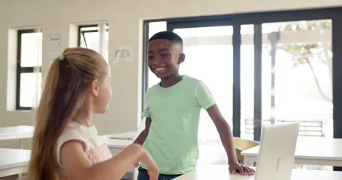 Diverse child peers in class high-fiving, boy raising hand, walking back, girl Stock Footage 335808875